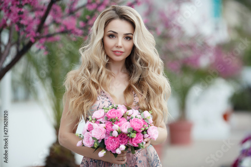 Beautiful woman in elegant evening dress.Blonde Girl with Long Healthy and curly hair. Beautiful young woman, model, in an evening dress.A portrait of a beautiful elegant woman outdoors 