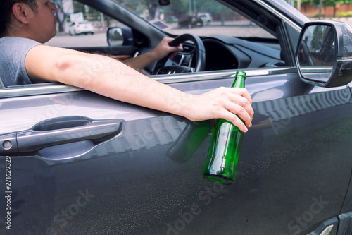 Don't Drink for Drive concept, Young Drunk man drinking bottle of beer or alcohol during driving the car dangerously © snowing12