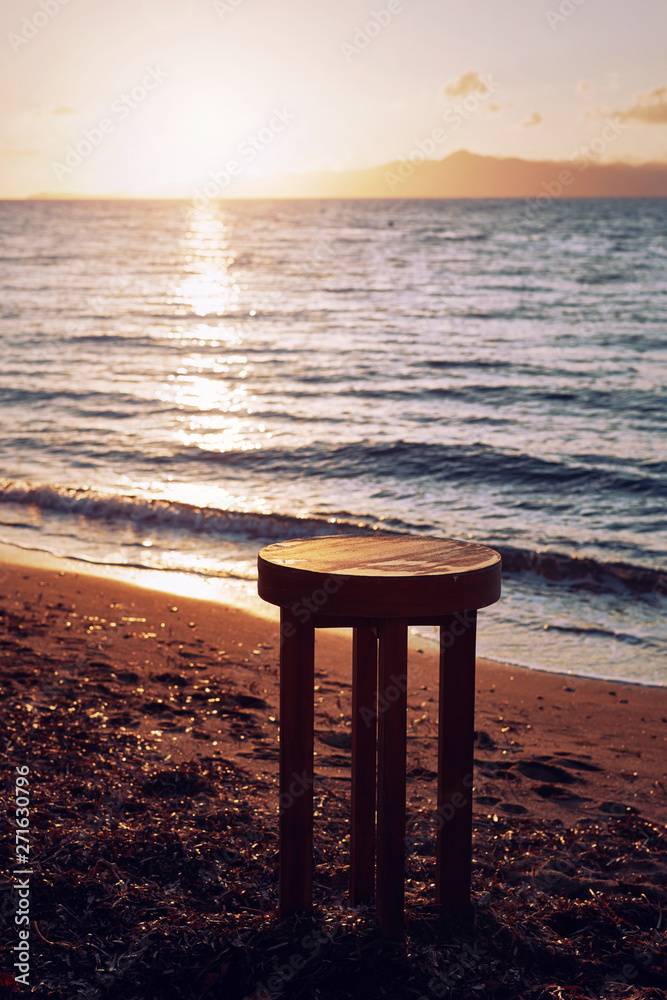 Brown wooden table stool on the beach for background backdrop use