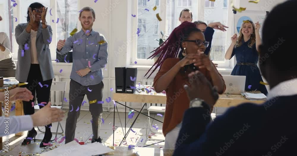 Healthy multiethnic workplace. Fun happy diverse business women doing celebration confetti dance at office workplace.