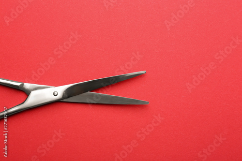 Pair of sharp scissors on color background, top view. Space for text