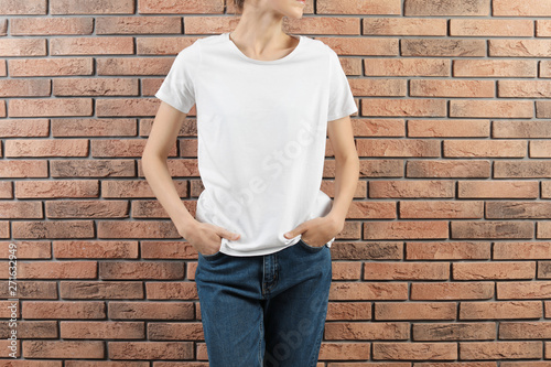 Woman in white t-shirt near brick wall. Mock up for design
