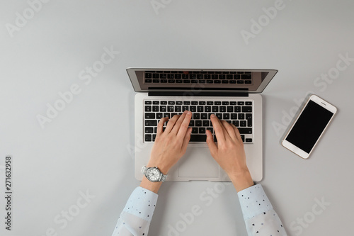 Woman using modern laptop at table, top view. Space for text