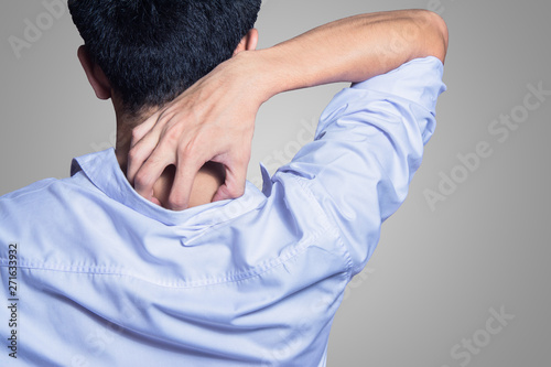 young man hands scratching the itch on the back with shirt photo