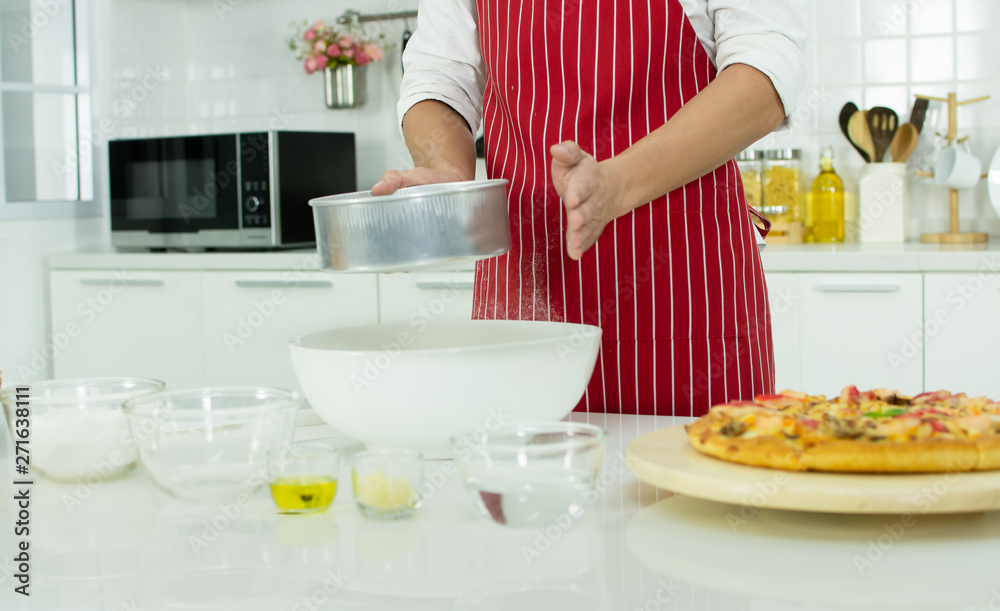 A man is making a homemade pizza