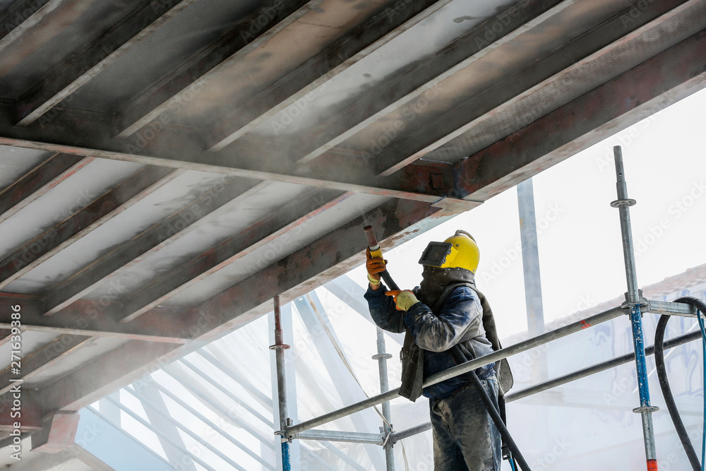 Fototapeta premium Sand blasting process Industial worker using sand blasting process preparation cleaning surface on steel before painting