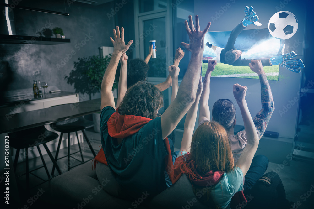 © alphaspirit - Group of friends watch the game together on television and rejoice © alphaspirit - Group of friends watch the game together on television and rejoice