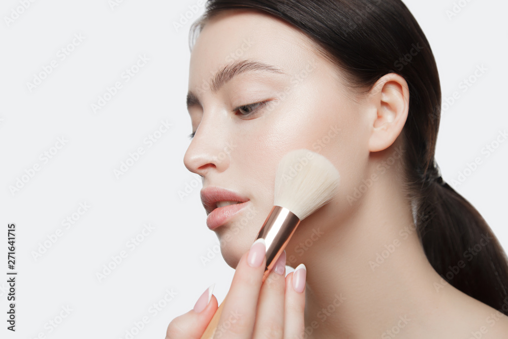 the young beautiful girl does herself a make-up the young beautiful girl does herself a make-up