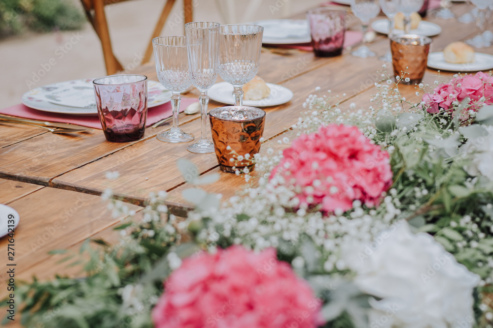 Finca decorada el día de la boda, mesas con tonos rosas y luces en el aire