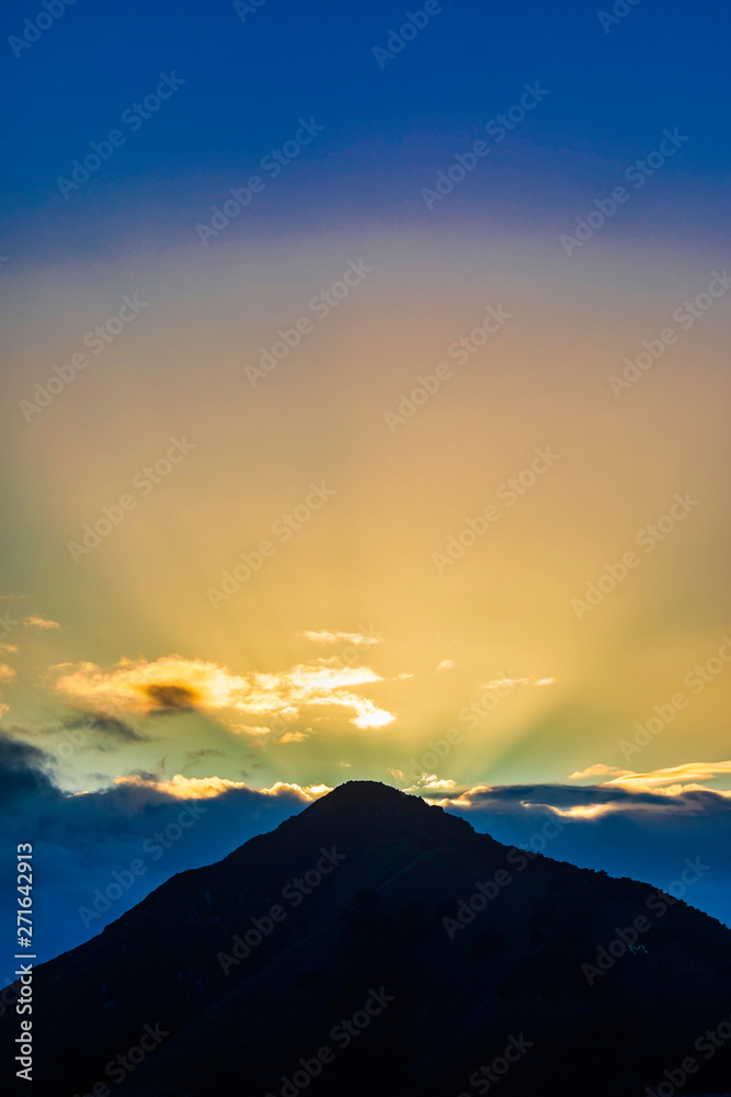 Sunrise over Mountain Peak with Rays of Light