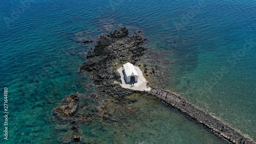 Aerial drone photo of famous for wedding ceremonies chapel of Agios Nikolaos built at sea with a small path connecting to mainland, Georgioupoli, Chania, Crete island, Greece photo