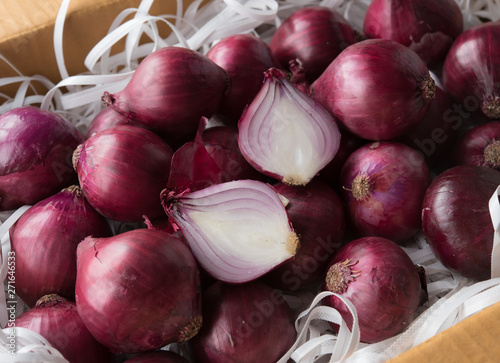 Fresh whole purple onions in the box for packing product