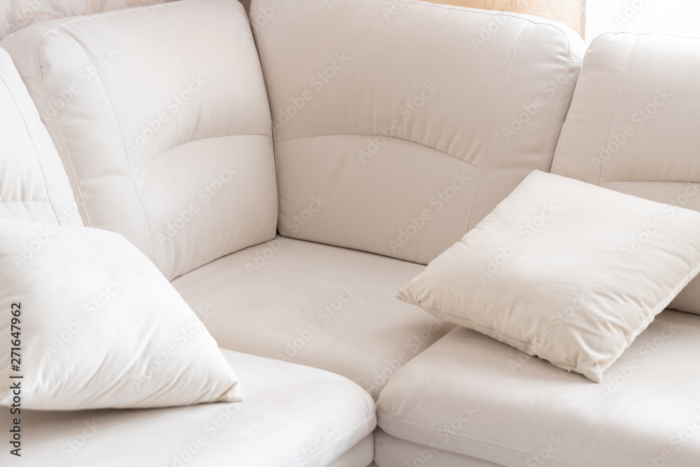 Empty white corner sofa with a pillows