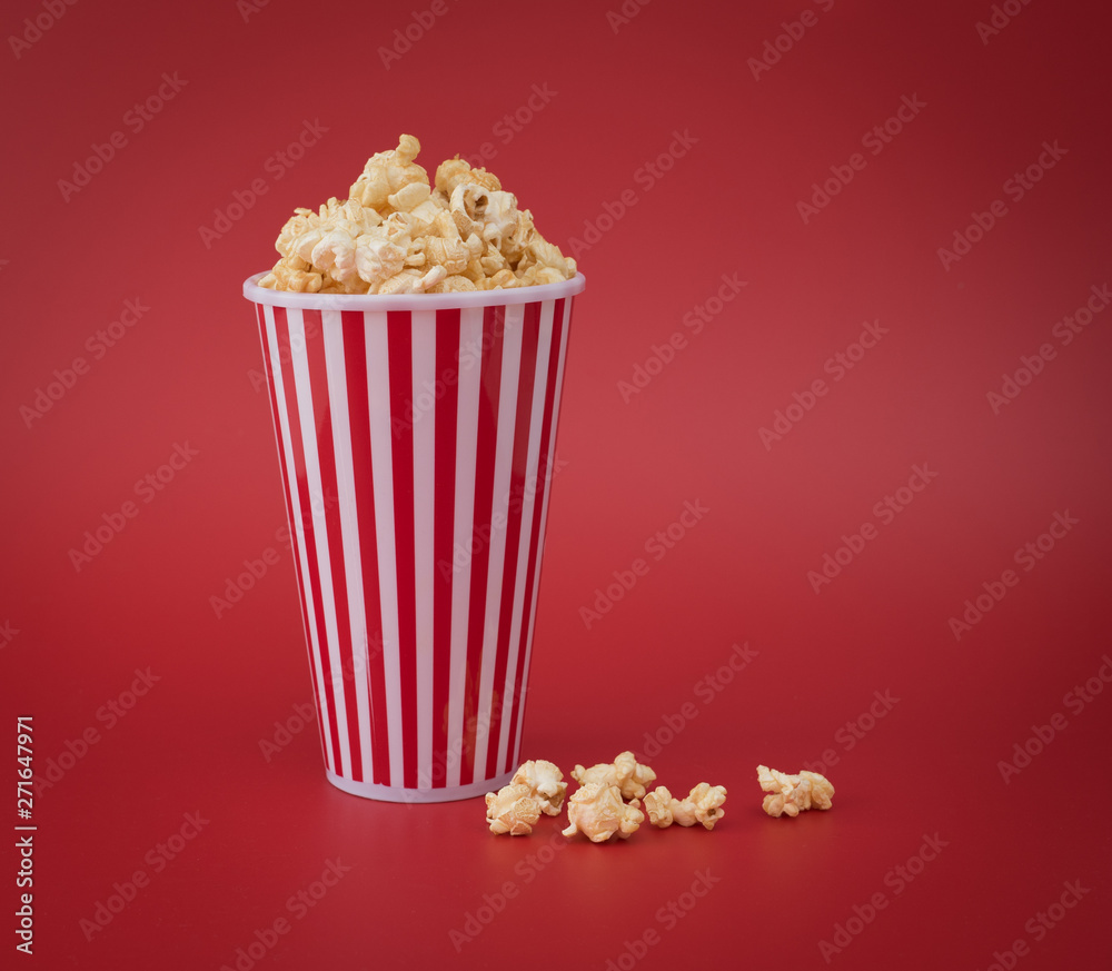Full red bucket of popcorn against red background