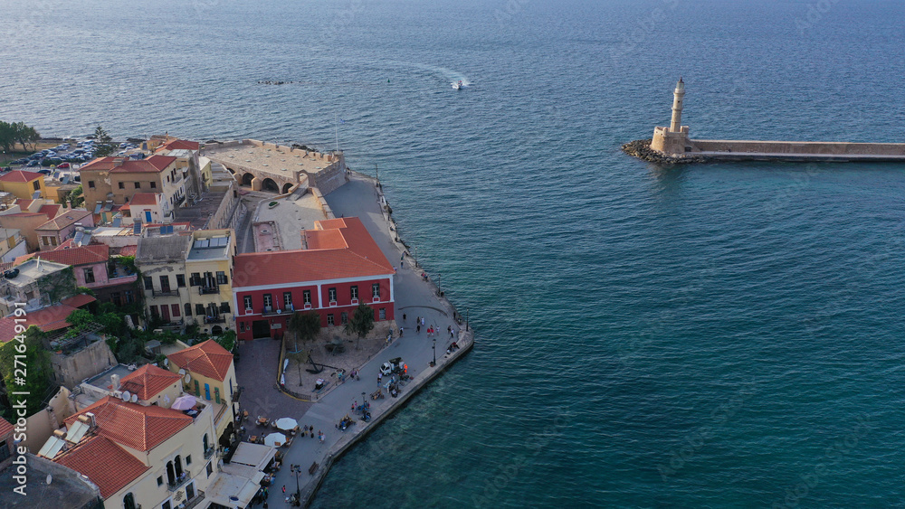 Aerial drone photo of iconic Venetian lighthouse in the entrance of picturesque old port of Chania at sunset with beautiful colours, Crete island, Greece