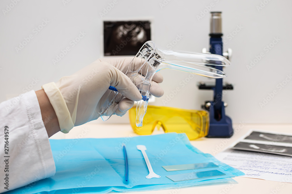 Doctor gynecologist preparing for pelvic examination with sterile vaginal speculum. Health care