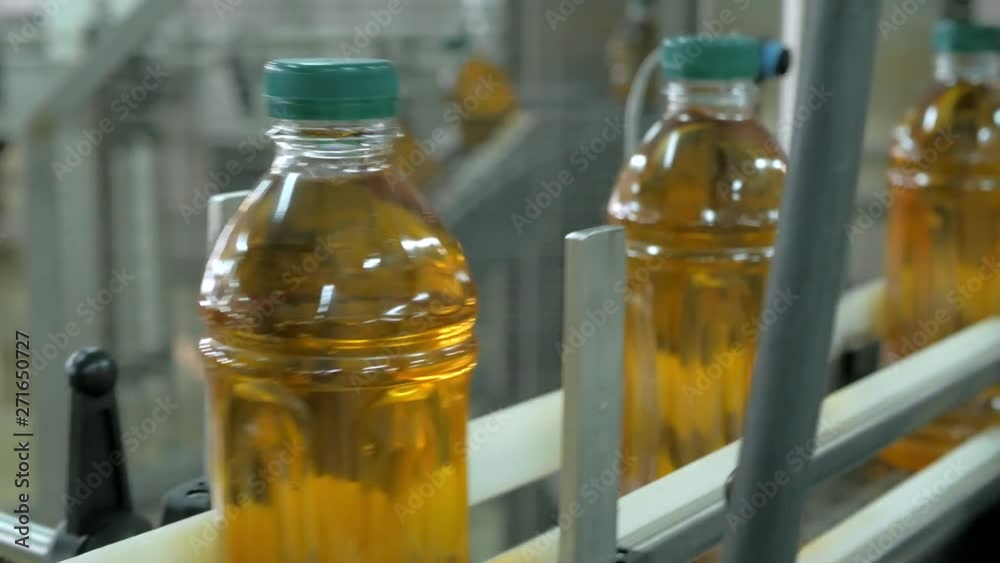 Automatic conveyor belt of production line of juice on beverage plant or factory, modern computerized industrial equipment. Fresh juice in plastic bottles Automatic conveyor belt of production line of juice on beverage plant or factory, modern computerized industrial equipment. Fresh juice in plastic bottles