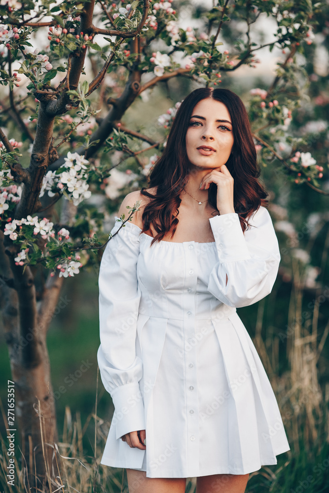Beautiful young woman close-up in white blouse, against green of summer park. Beautiful young woman close-up in white blouse, against green of summer park.