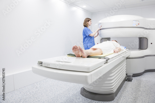 Middle-aged woman and her doctor in an open MRI machine waiting for the test to start