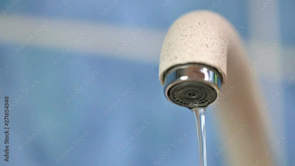 Dripping water from a water tap thin stream close-up. Faulty water faucet. Water leakage problem. Worldwide problem of safety of drinking fresh water. Conceptual video footage. Dripping water from a water tap thin stream close-up. Faulty water faucet. Water leakage problem. Worldwide problem of safety of drinking fresh water. Conceptual video footage.
