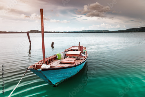 Fishery wooden boat at the shore lake scape.