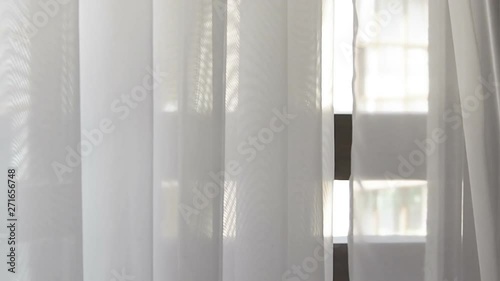White sheer curtains moving from wind at sunny day