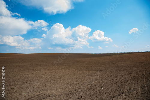 Empty brown soil of field and blue sky for natural background