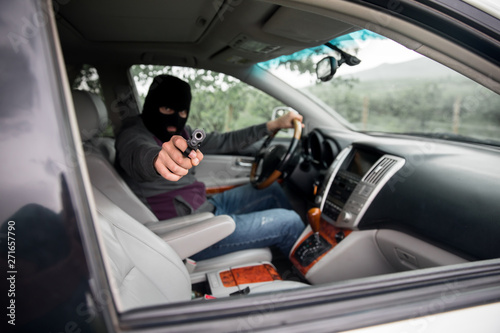 man driving car hand gun