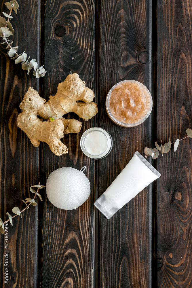 Organic cosmetics with ginger and herbs on wooden background top view