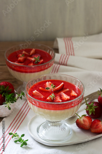 Obraz na płótnie Panna cotta with strawberry sauce and strawberry slices, decorated with thyme leaves. Rustic style. w salonie