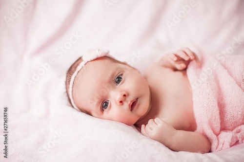 Little newborn baby in a pink suit on a pink background. Motherhood.