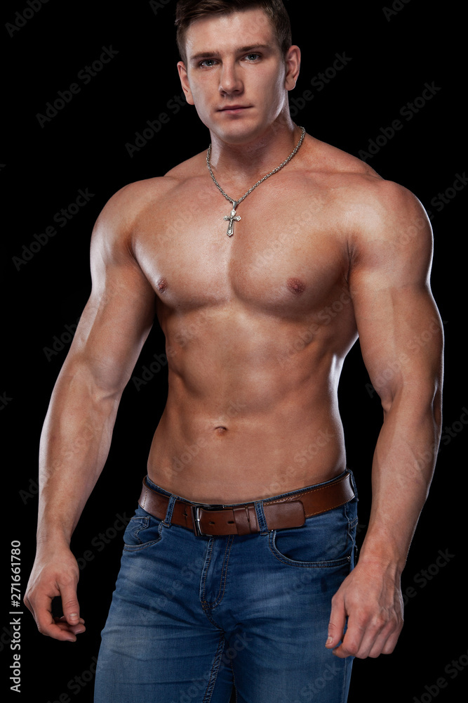 Fototapeta premium Bodybuilding competitions on the scene. Man sportsmen physique and athlete. Black background with lights.