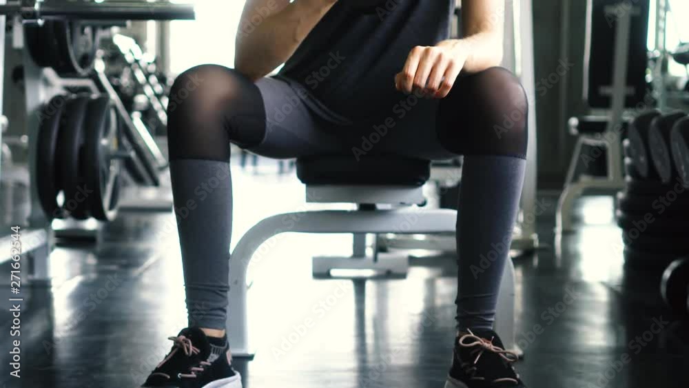 Young woman in sportswear doing seated dumbbell concentration curl bicep exercise at the gym Young woman in sportswear doing seated dumbbell concentration curl bicep exercise at the gym