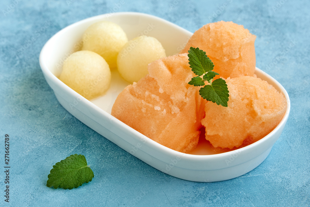 Homemade melon ice cream , sorbet with melon balls and mint leaves. Closeup Homemade melon ice cream , sorbet with melon balls and mint leaves. Closeup