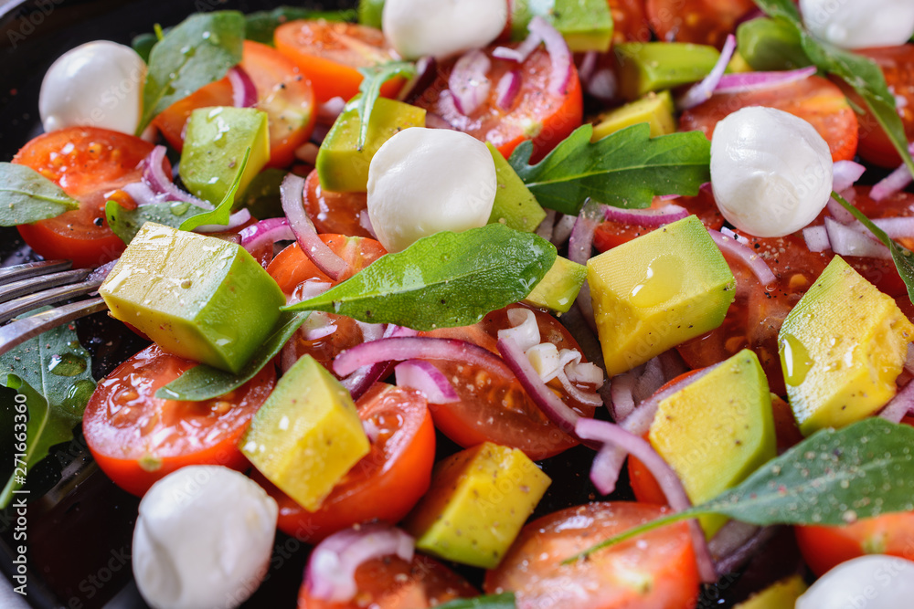 Colorful and tasty salad with avocado, cherry tomatoes and mozzarella, macro