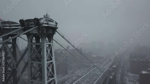 Fog covers Williamsburg Bridge in winter, aerial