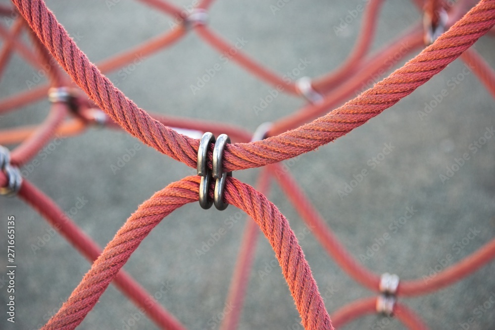 Red ropes connected by reef metal knot Red ropes connected by reef metal knot