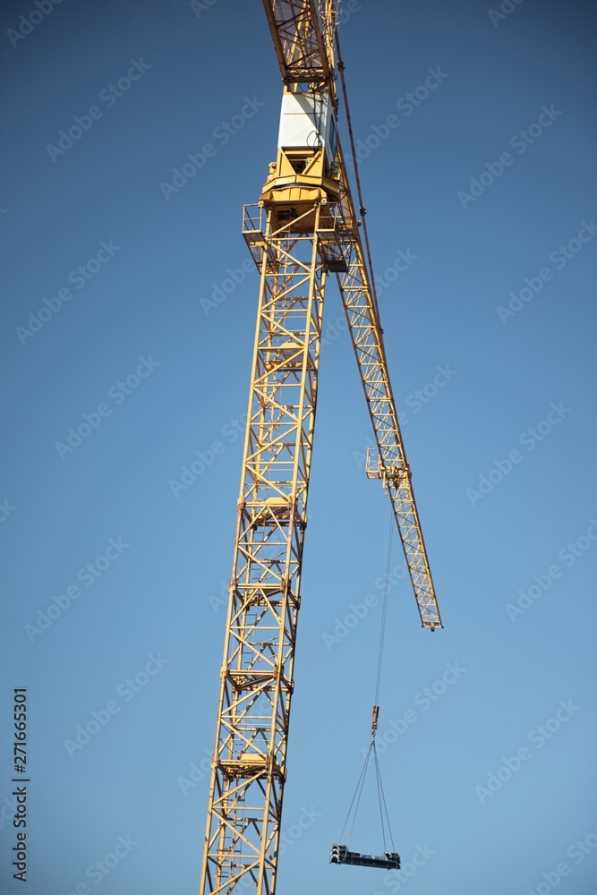 Crane. Construction crane. Huge crane against blue sky. Tower crane. Crane. Construction crane. Huge crane against blue sky. Tower crane.