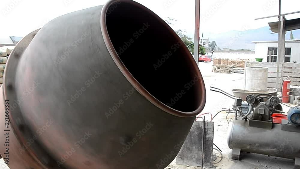 Industrial cement mixer machine at construction site. Concrete pouring. Mixes the sand, gravel and water. Close-up. Industrial cement mixer machine at construction site. Concrete pouring. Mixes the sand, gravel and water. Close-up.