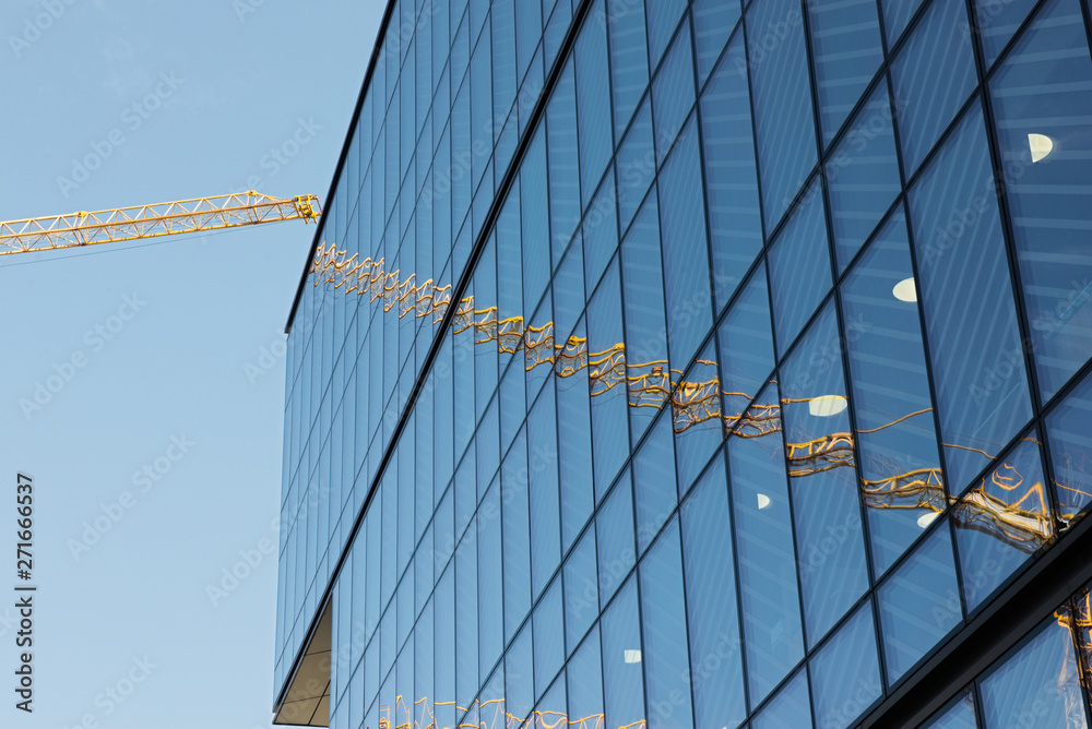 A crane sits at the base of many modern buildings.