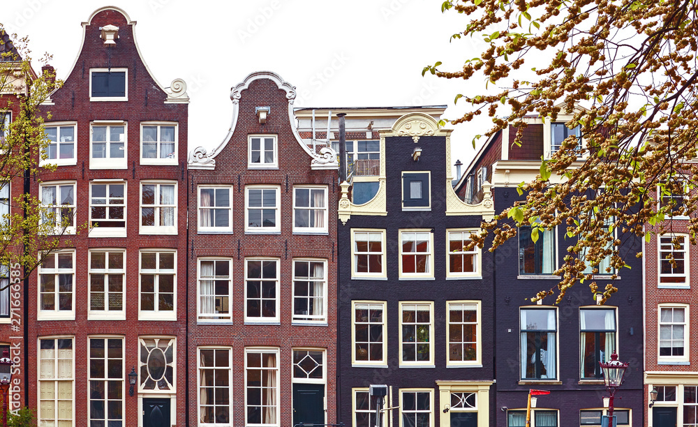 Amsterdam Netherlands dancing houses with traditional deutch windows. Landmark in old european city. Architectural details and roofs.