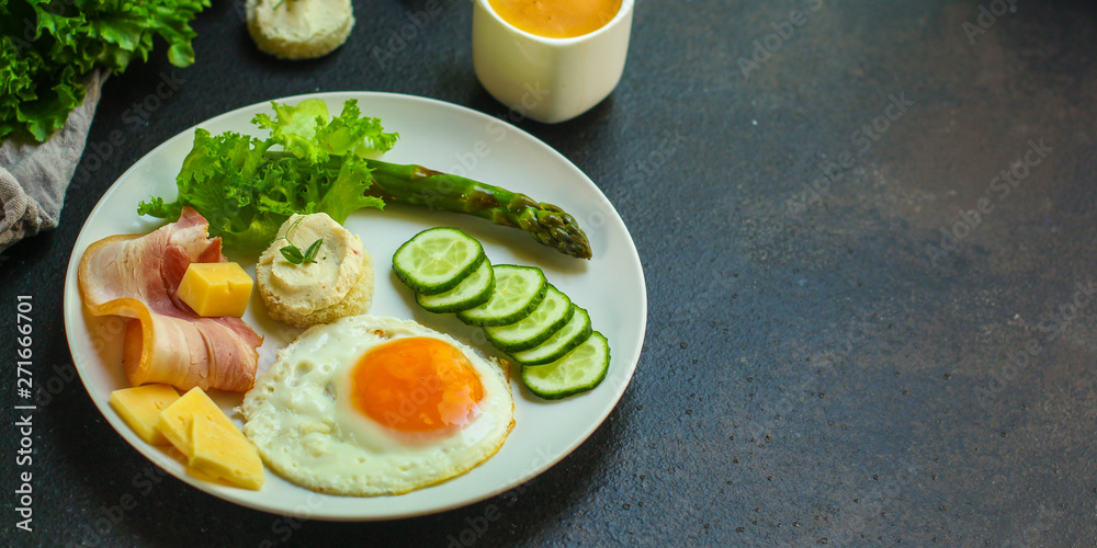 breakfast - fried eggs, lettuce, lettuce, cucumbers, asparagus, bacon, sauce and more. top. food background. space for text and lettering breakfast - fried eggs, lettuce, lettuce, cucumbers, asparagus, bacon, sauce and more. top. food background. space for text and lettering
