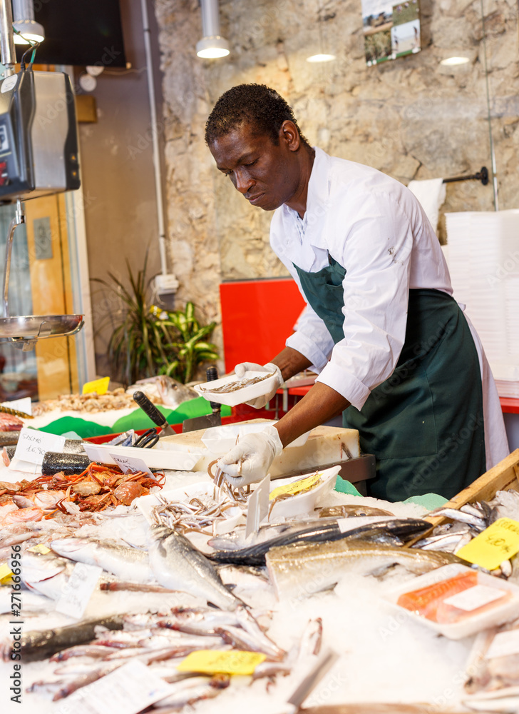 Salesman preparing fish for sale