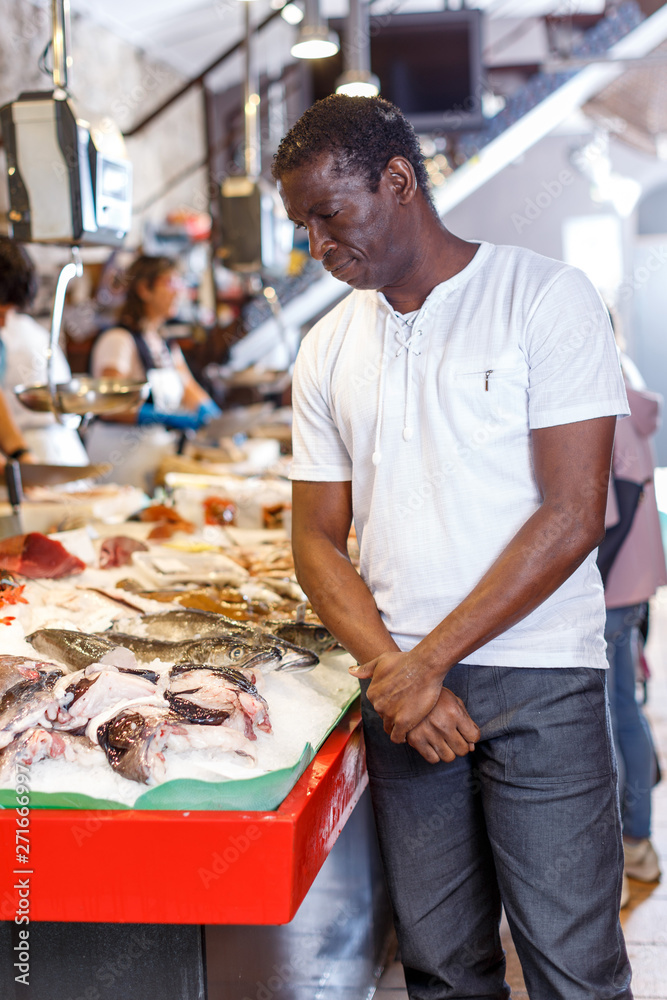 Man choosing fresh seafood in shop