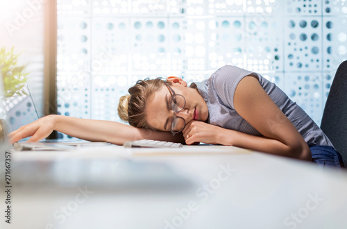 Young businesswoman asleep at her desk in an office