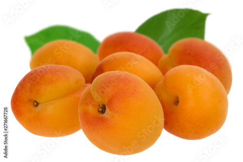 big heap of apricots with green leaves isolated on white background
