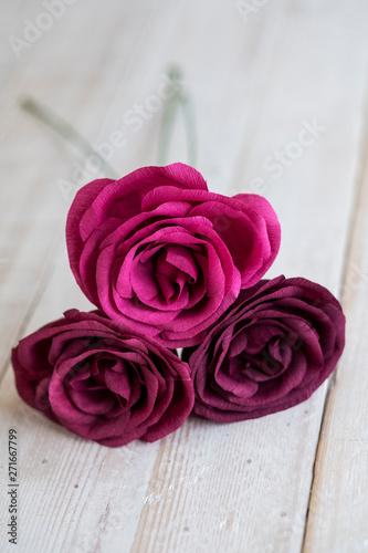 High angle close up of three pink and purple paper roses. photo