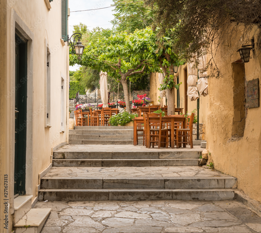 Obraz premium Empty Taverna on steps in ancient neighborhood of Plaka in Athens by the Acropolis