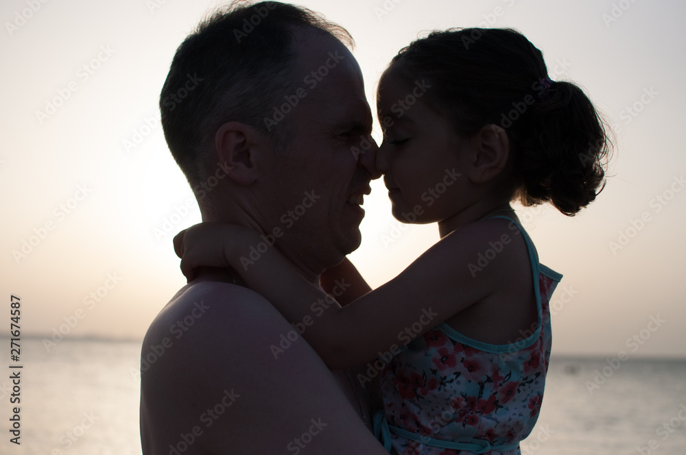 Summer. Father and daughter hugging on the beach.