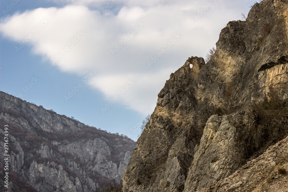 Pointy rock with a hole at the summit of a rocky mountain in the canyon of Jerma river in Serbia